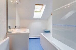 A modern bathroom with a skylight, a bathtub, and a sink. - La Dorine - Charmant cocon pour 2 en campagne (Parfondeval)