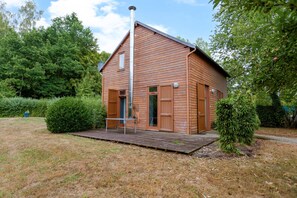 A wooden house with a porch, a chimney, and a door. - La Dorine - Charmant cocon pour 2 en campagne (Parfondeval)