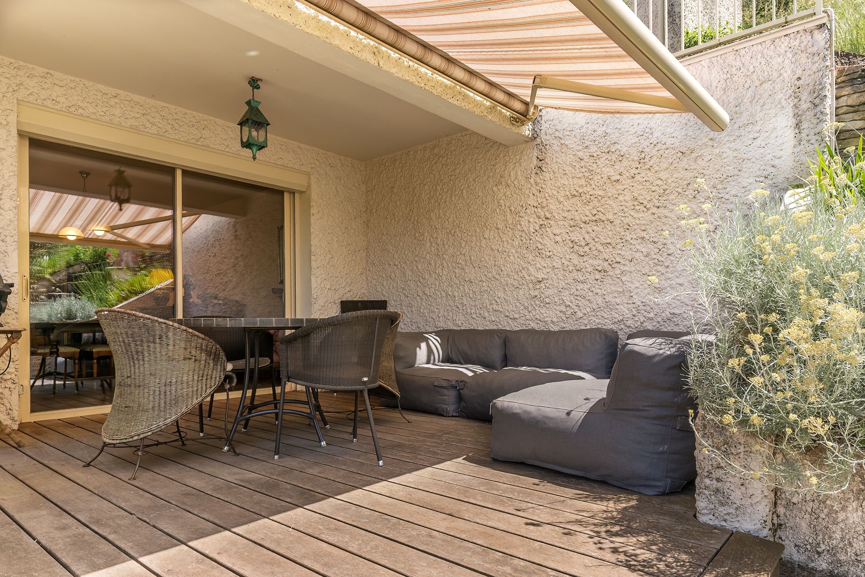 Une terrasse extérieure avec une table à manger, des chaises et un canapé.