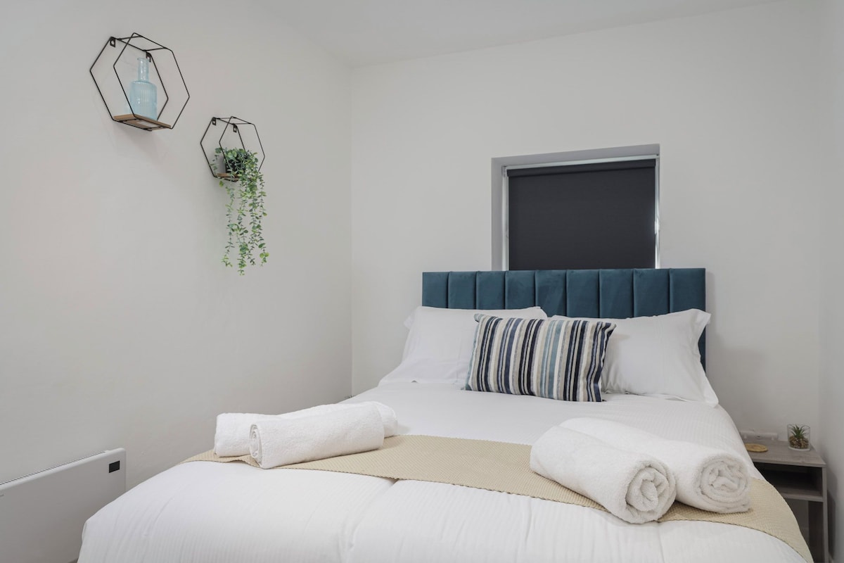 A bedroom with a bed, a window, and two wall-mounted planters.