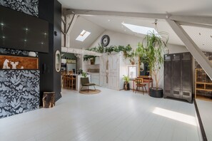 Une cuisine spacieuse avec un coin repas, une grande fenêtre et un escalier.