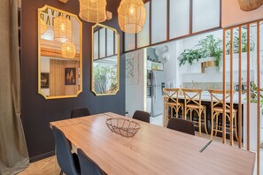 A modern dining area with a wooden table, chairs, and a decorative wire basket. - The White Forest - Proche Epinal (Thaon-les-Vosges)