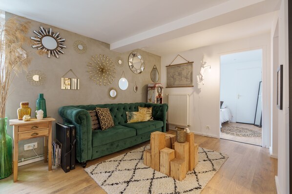 A living room with a green sofa, decorative mirrors, a world map, and a wooden coffee table. - The White Forest - Proche Epinal (Thaon-les-Vosges)