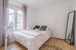 A bedroom with a bed, a window, a fan, and a mirror. - The White Forest - Proche Epinal (Thaon-les-Vosges)
