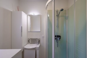 A bathroom with a glass-enclosed shower, a white sink, and a cabinet. - Ti Donnart - 10min du Centre de Brest (Brest)