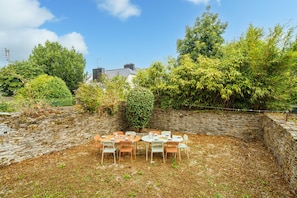 An outdoor dining area with stone walls and a variety of trees and plants. - Ti Donnart - 10min du Centre de Brest (Brest)
