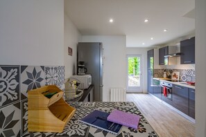 Une cuisine moderne dotée d’un four encastré, d’une machine à café et offrant une vue sur l’extérieur.
