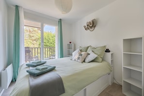 A bedroom with a bed, a window, a balcony, and a wall-mounted shelf. - Cocon Entre Mer, Nature et Histoire (Blonville-sur-Mer)