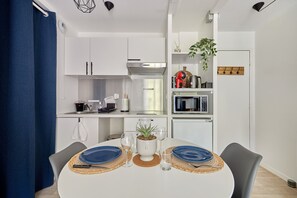 A modern kitchen with white cabinets, a built-in oven, and a microwave. - Cocon Entre Mer, Nature et Histoire (Blonville-sur-Mer)