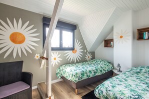 A room with two beds, a window, a bookshelf, and a chair. - Beach house Sainte-Cécile - Avec beau jardin (Camiers)