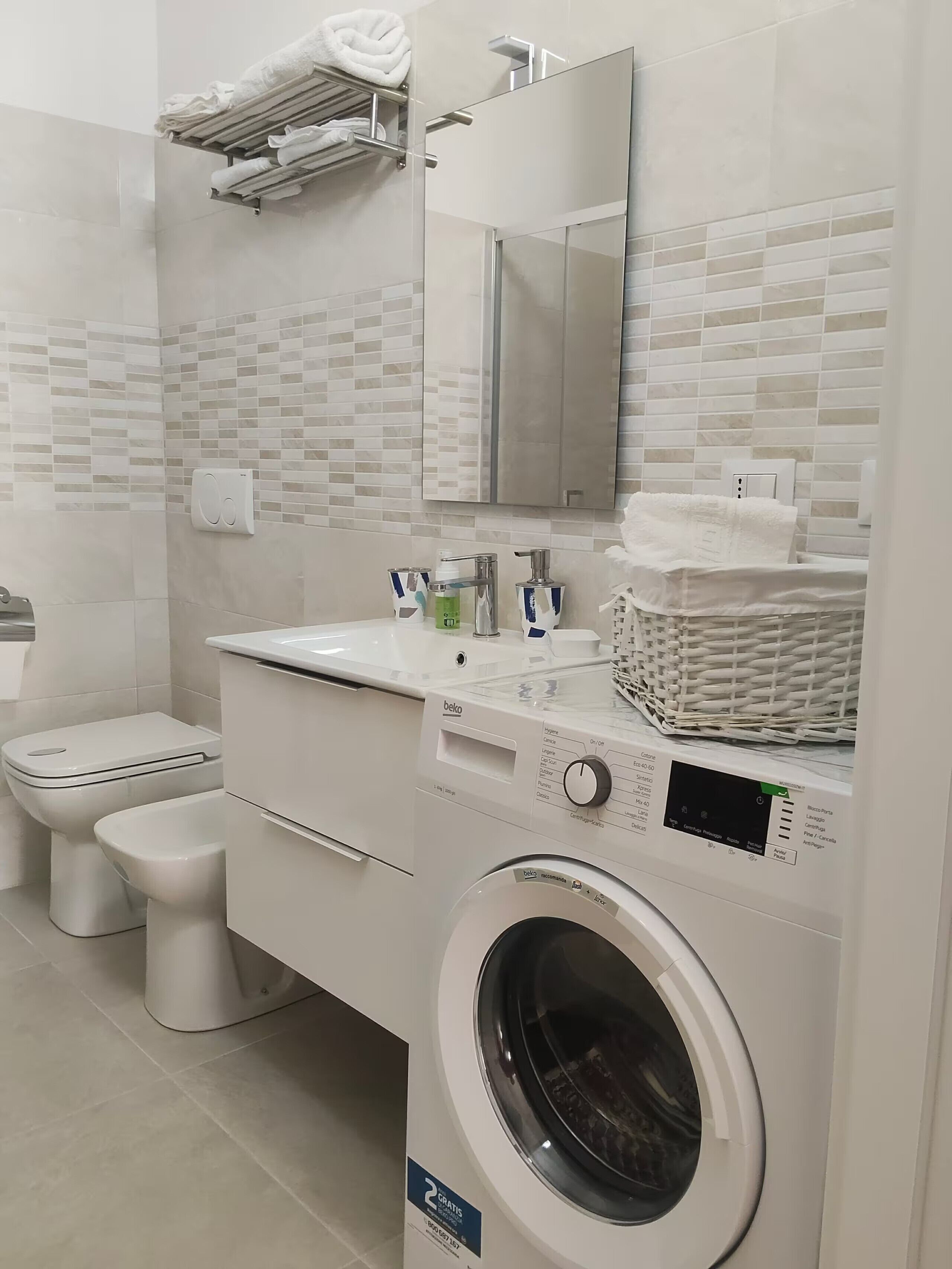Ein modernes Badezimmer mit Waschmaschine, Toilette und Waschbecken.