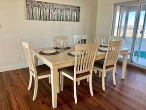 A dining area with a table set for six, surrounded by six chairs. - Farmhouse in New Sharon (New Sharon)