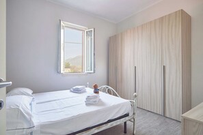 Ein Schlafzimmer mit einem Bett, einem Fenster und einem Kleiderschrank.