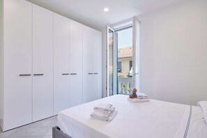 A bedroom with a bed, a wardrobe, and a view of the outside. - Casa Maggie - One Bedroom Apartment, Sleeps 4 (Albenga)
