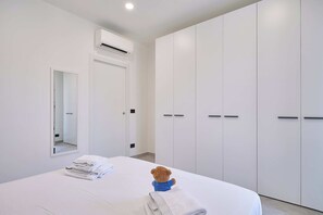 A hotel room with a bed, a teddy bear, and a wardrobe. - Casa Maggie - One Bedroom Apartment, Sleeps 4 (Albenga)
