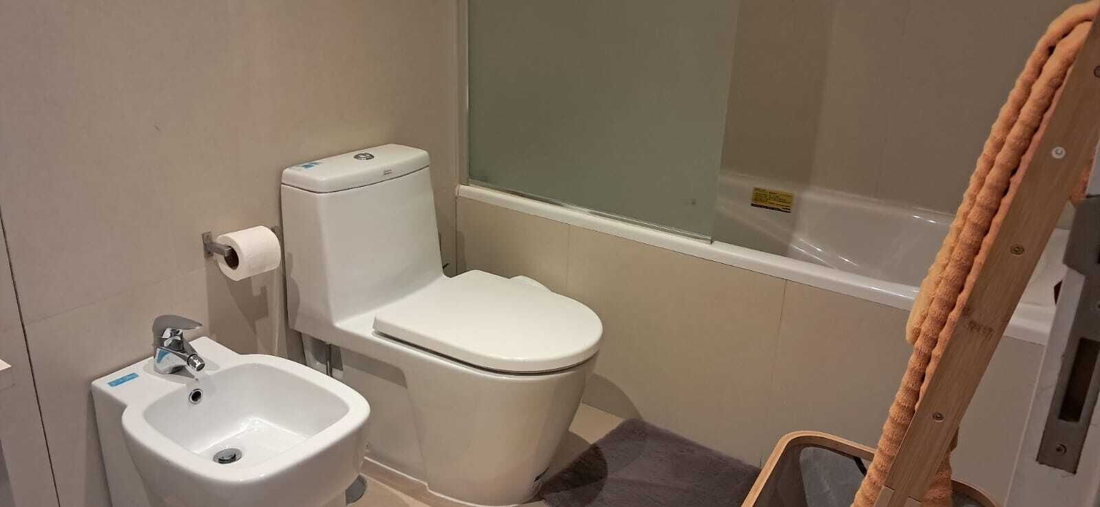 Une salle de bain équipée de toilettes, d’un bidet et d’une baignoire.