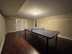 A room with a ping pong table, a door, and a window. - Superb 4-bedroom house with AC  and large deck in charming Oxford,ohio (Oxford)