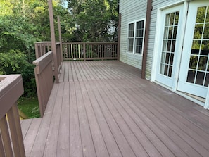 A wooden deck with a railing, surrounded by greenery and a house with white-framed windows. - Superb 4-bedroom house with AC  and large deck in charming Oxford,ohio (Oxford)