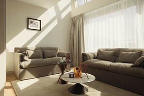 A modern living room with two sofas, a coffee table, and a framed picture on the wall.
