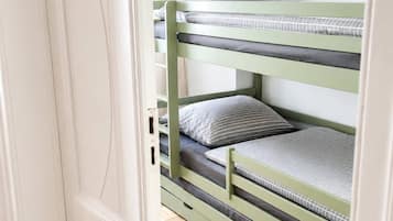 Ein Etagenbett mit Holzboden in Fischgrätmuster.