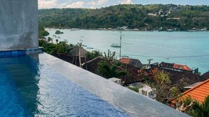 Una piscina con vistas a una zona costera, que incluye una masa de agua y un paisaje montañoso.