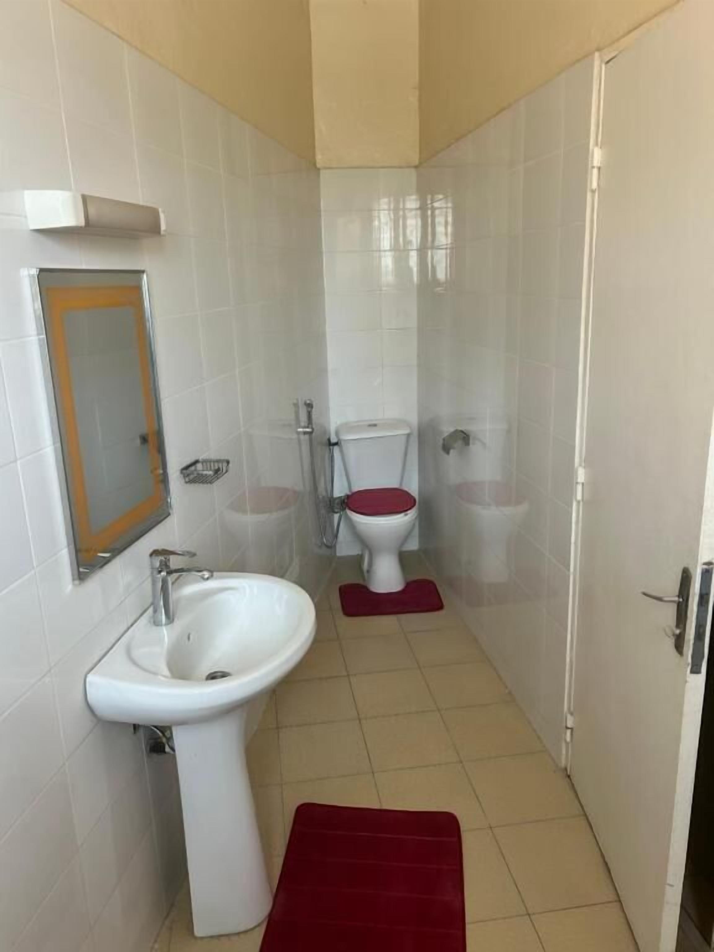 Une salle de bain avec un lavabo blanc, des toilettes et un espace douche.