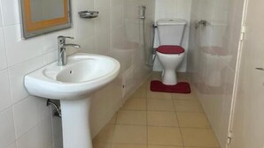 Een badkamer met een wit wastafel, toilet en spiegel.