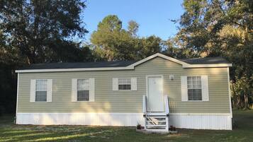A single-story house with a front porch, a small staircase, and a covered entryway.