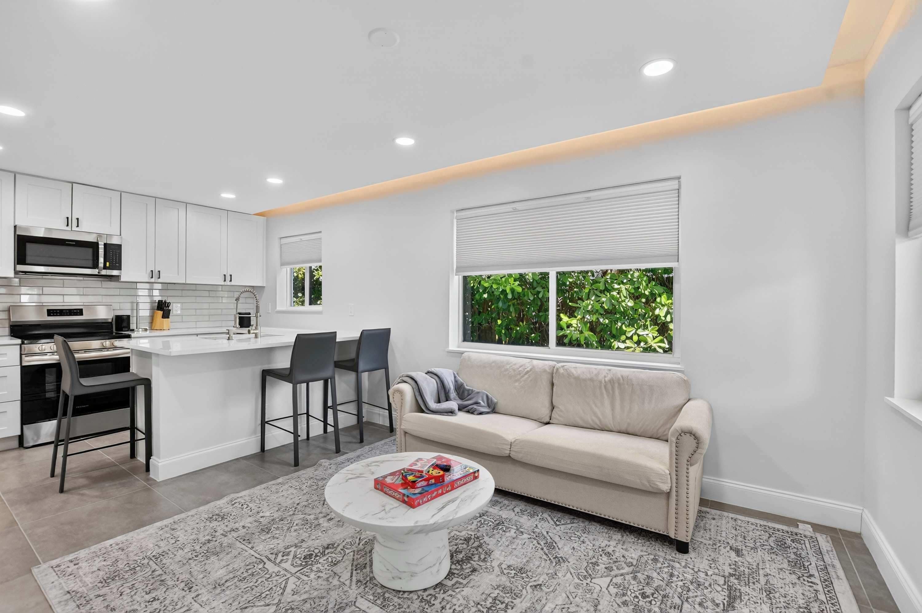 A modern kitchen with white cabinets, a built-in microwave, and a stainless steel stove.