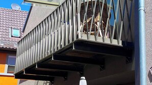 A modern building with a balcony featuring a glass enclosure and metal railing. - Holiday Home - Cityhouse WG9 - 6 Guests - 3BR (Marktheidenfeld)