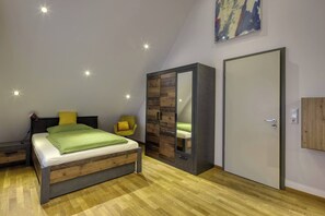 Ein Schlafzimmer mit Bett, Stuhl, Kleiderschrank und Tür.
