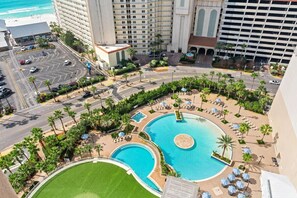 A hotel complex with multiple swimming pools, a parking area, and a view of the ocean. - 🏖️Laketown Wharf 316~Walk to Beach~5 Pools~ Putting Green~ Fitness Center🏖️ (Panama City)