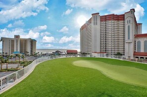 A hotel with a large lawn, multiple buildings, and a clear sky. - 🏖️Laketown Wharf 316~Walk to Beach~5 Pools~ Putting Green~ Fitness Center🏖️ (Panama City)