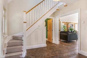 A staircase with carpeted steps and white railings, leading to a room with a herringbone floor pattern. - Bromley Retreat: Spacious Townhouse w/Parking (Bromley)