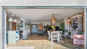 Ein modernes Interieur mit Essbereich, Küche und Wohnbereich.