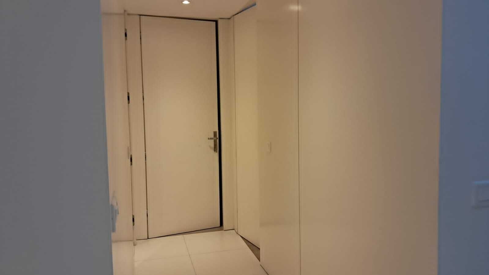 A narrow hallway with a closed door at the end.