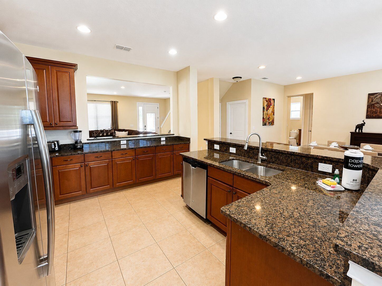 A modern kitchen with granite countertops, stainless steel appliances, and wooden cabinets.