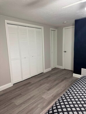 Ein Schlafzimmer mit einem Bett, einem Kleiderschrank und einer Tür.
