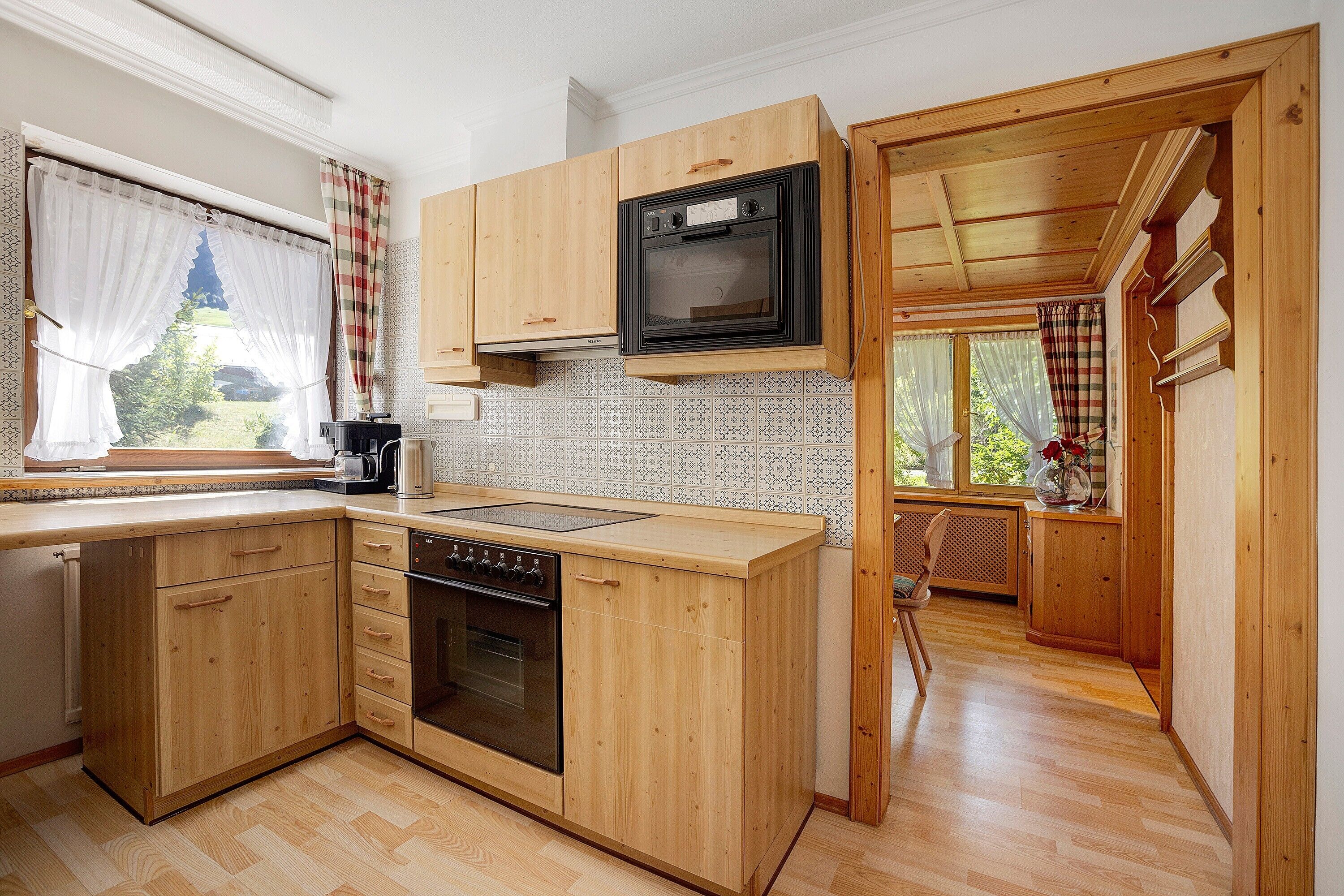 A compact kitchen with wooden cabinets, a built-in microwave, and a dishwasher.