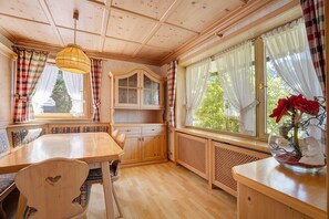Interior de madera con una mesa, bancos, un armario y un radiador.