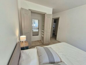 Ein Hotelzimmer mit einem Bett, einem Nachttisch, einer Lampe und einem Spiegel.