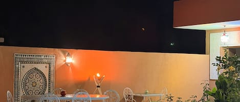 Un área de piscina al aire libre con una zona de comedor y una pared decorativa.