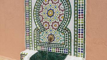 A tiled fountain with a geometric pattern and a central water spout.