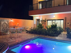 An outdoor pool area with a dining setup and a balcony. - Atlas Peak Blue (Sidi Abdallah Ghiat)