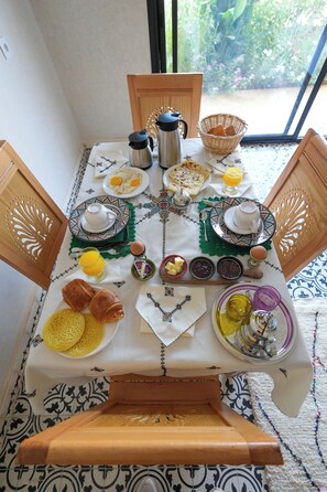 A breakfast table set with various dishes, including eggs, bread, and a coffee pot.