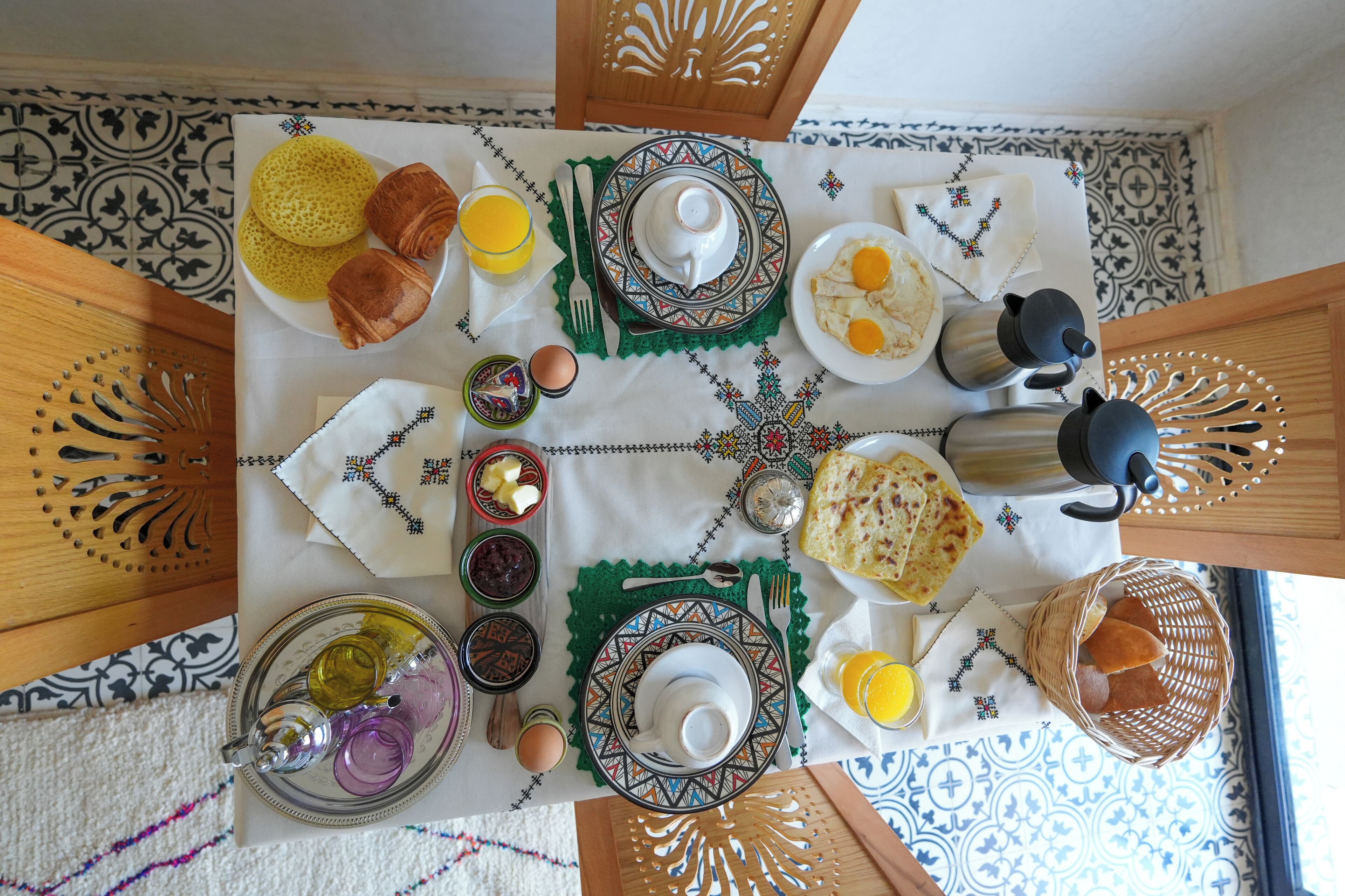 A breakfast table set with various dishes, including eggs, toast, and a beverage.