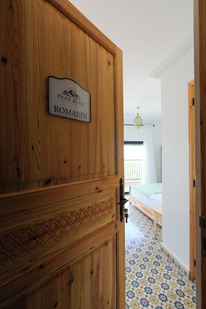 A wooden door with a sign reading 'PEAK BLUE ATLAS ROMARIN'.