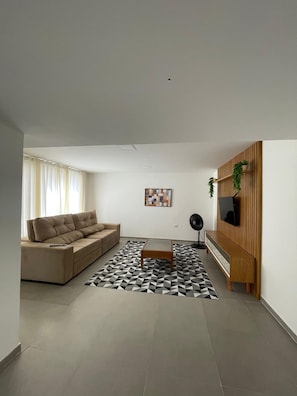 Ein modernes Wohnzimmer mit einer Couch, einem Couchtisch und einem gemusterten Teppich.