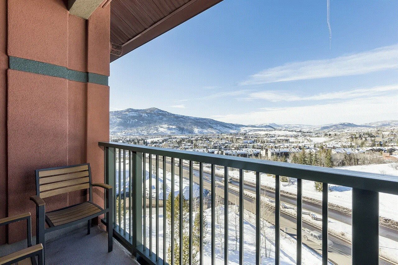 Un balcon avec un banc donnant sur un paysage enneigé, avec des montagnes à l’horizon.