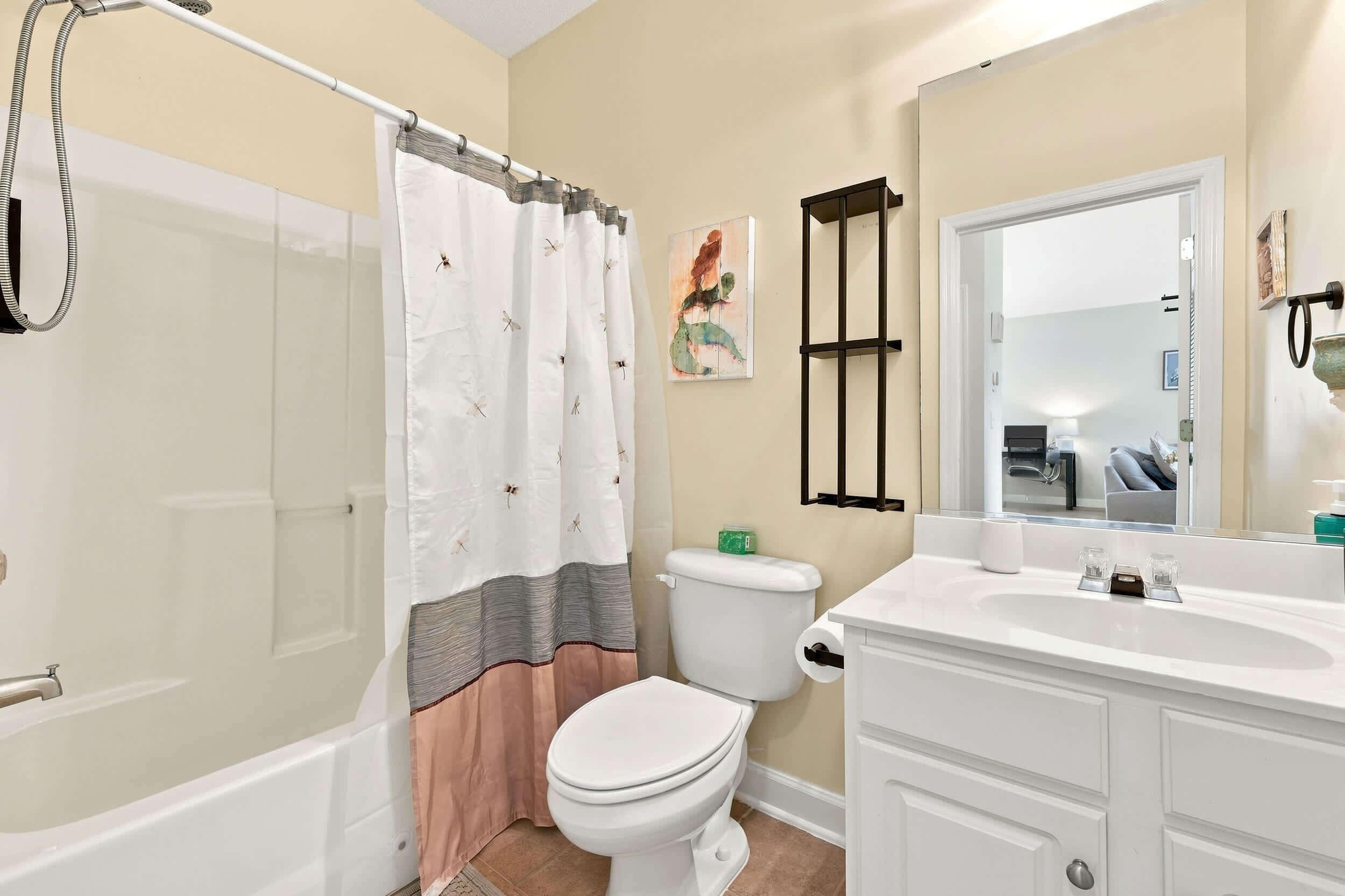 A bathroom with a shower, toilet, and sink.